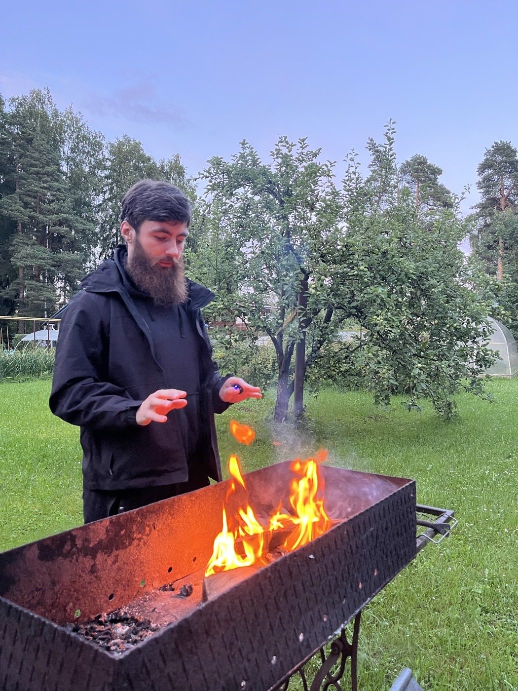 Сергей разжигает мангал на даче
